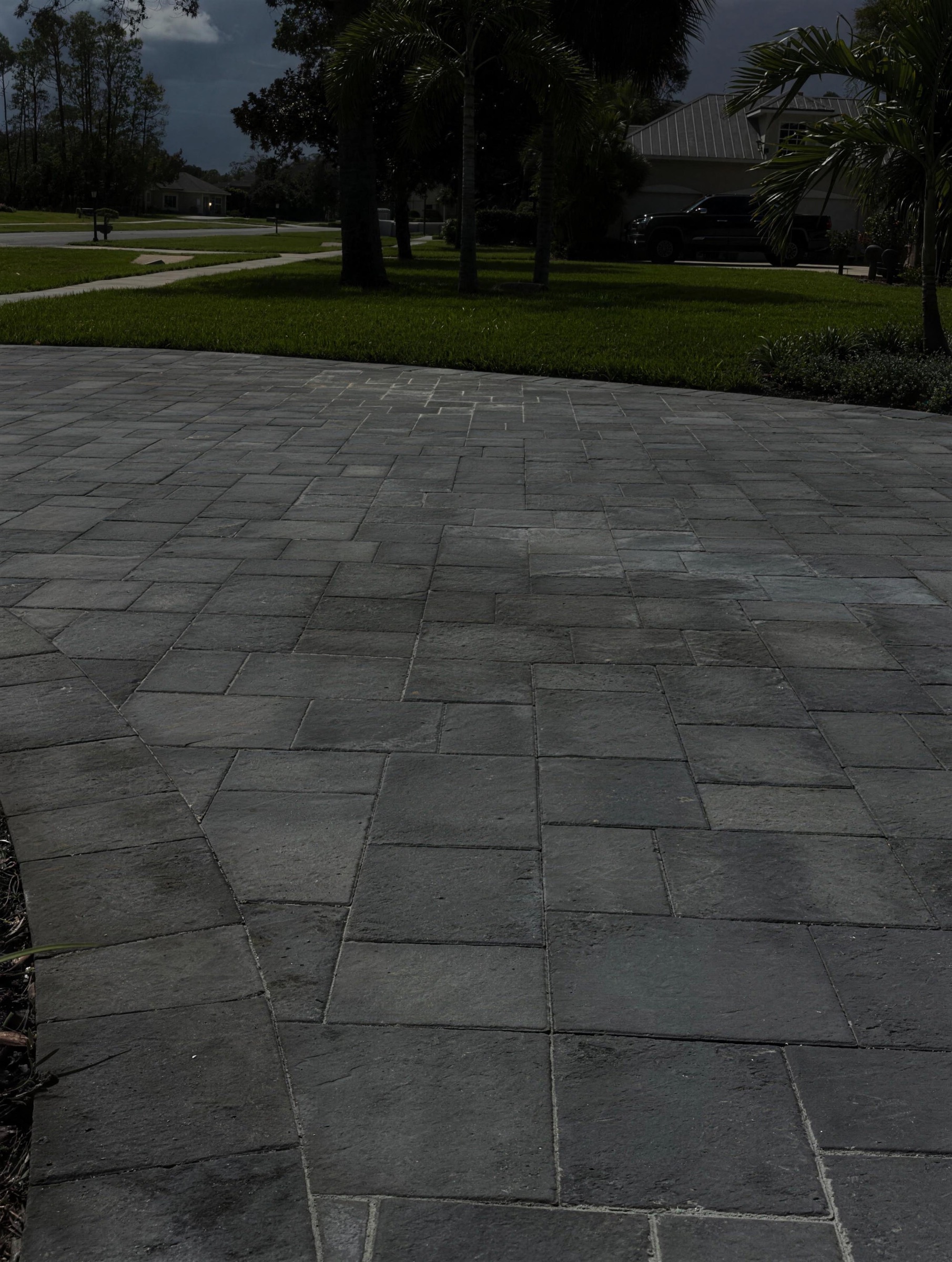Sealed paver driveway at dusk with wet-look finish